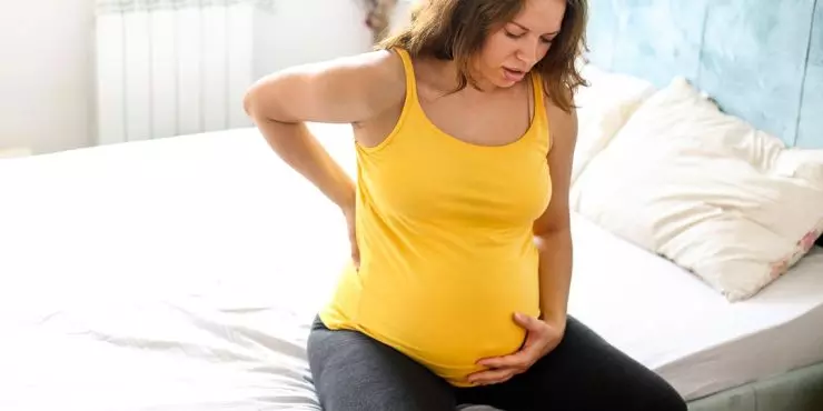 Pregnant woman supporting lower back